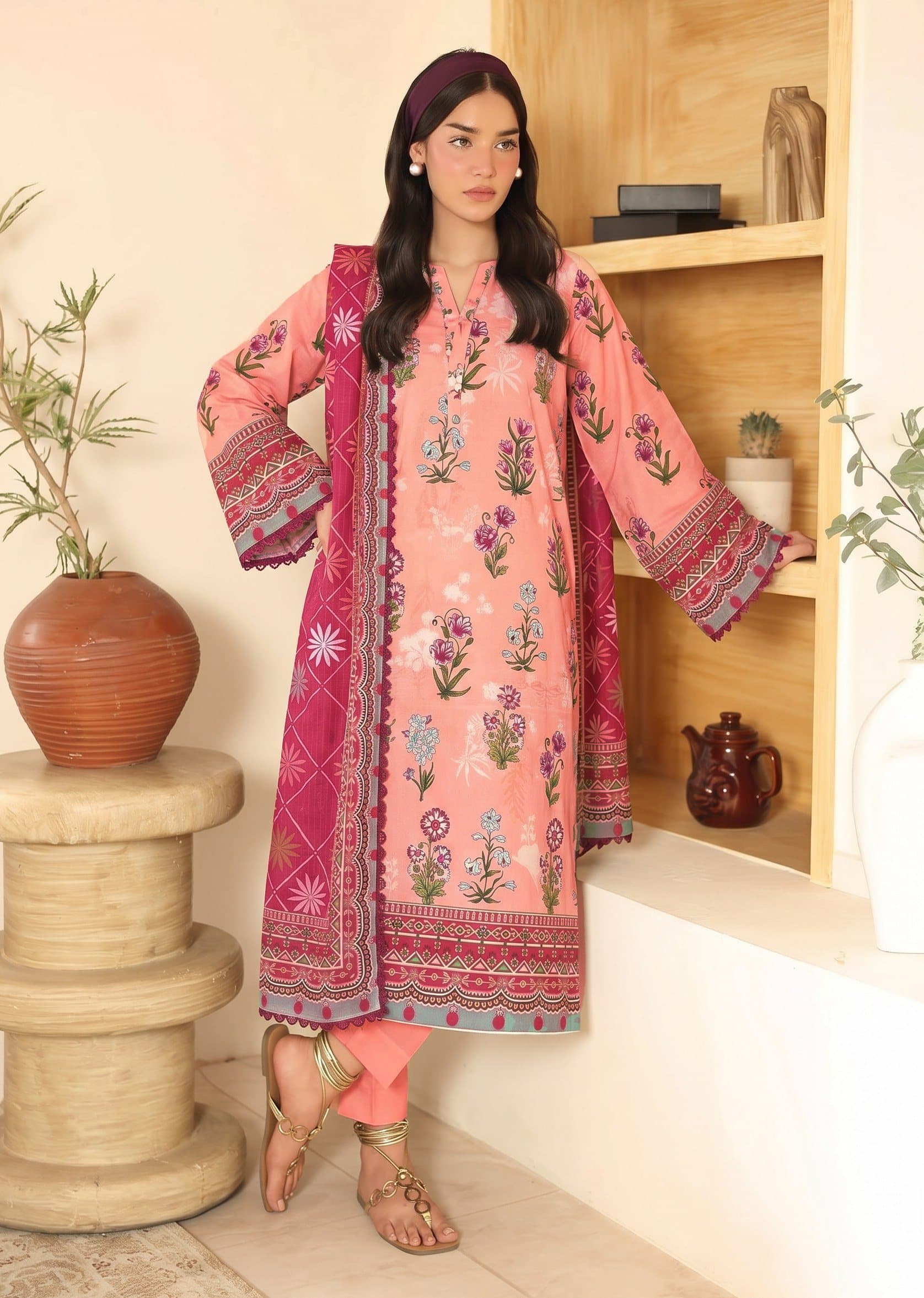 Model wearing a peach coral floral-print unstitched lawn suit — warm tones lifestyle shot